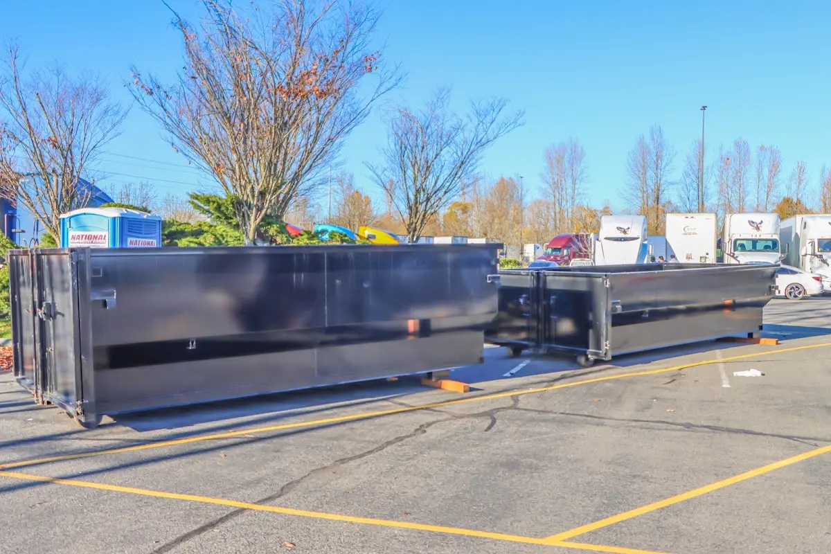 Professional dumpster rental service with roll-off container on residential driveway in Norwood